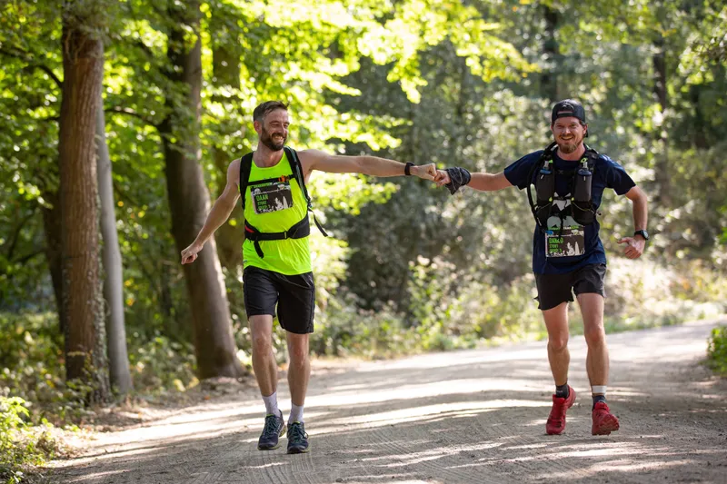 Hardlopers geven elkaar een vuistje tijdens een race